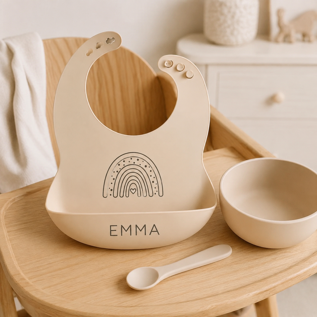 Bavoir bébé beige personnalisé motif arc-en-ciel sur une chaise haute