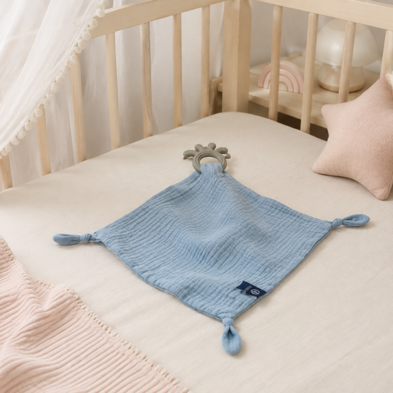 Doudou-lange bébé bleu en mousseline dans un lit bébé