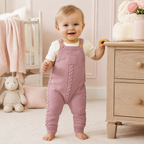 Bébé portant la barboteuse en tricot rose poudré