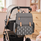 Sac à langer gris à motifs flèches suspendu à une poussette dans une chambre de bébé