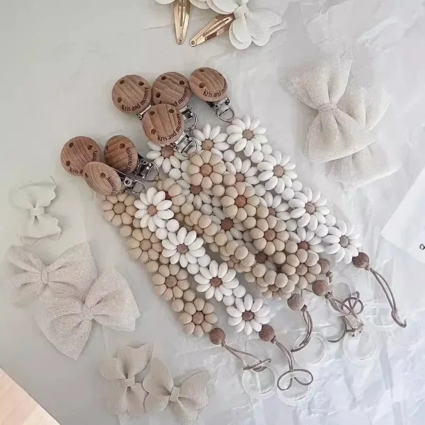 Attache Tétine Petite Fleur Marguerite, un accessoire adorable pour bébé, alliant praticité et style.