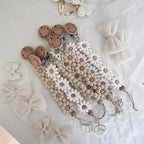 Attache Tétine Petite Fleur Marguerite, un accessoire adorable pour bébé, alliant praticité et style.