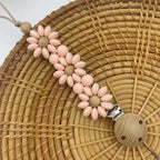 Attache Tétine Petite Fleur Marguerite, un accessoire joli et pratique pour garder la tétine à portée de main.