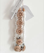 Attache Tétine Petite Fleur Marguerite, un accessoire chic et pratique pour bébé, en silicone de haute qualité.