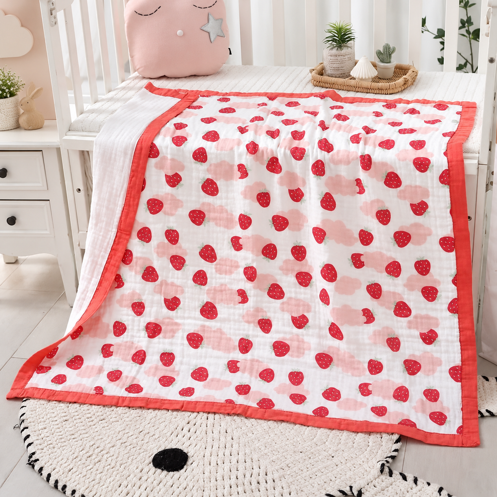 Couverture bébé en gaze de coton motif fraises rouges dans une chambre bébé
