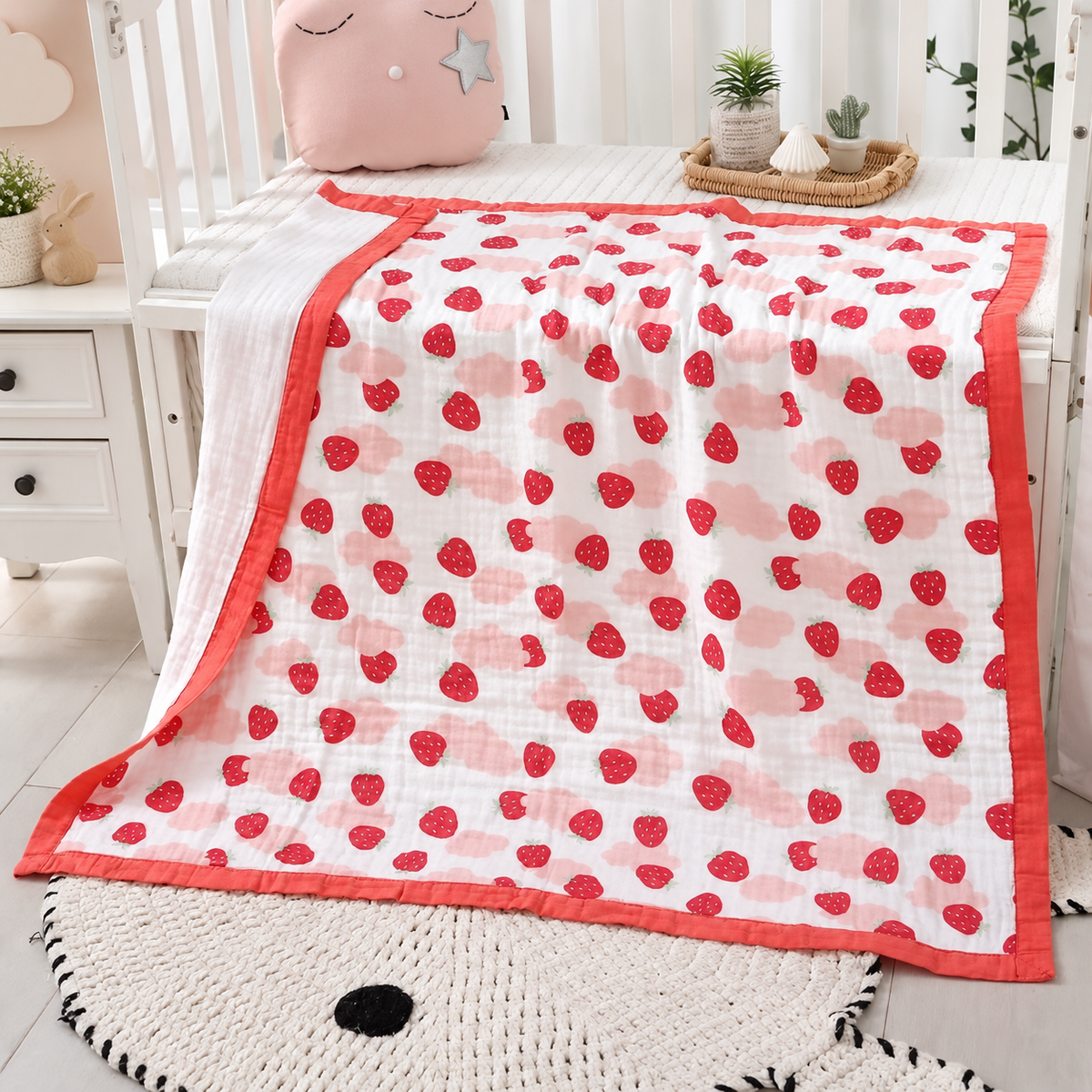 Couverture bébé en gaze de coton motif fraises rouges dans une chambre bébé