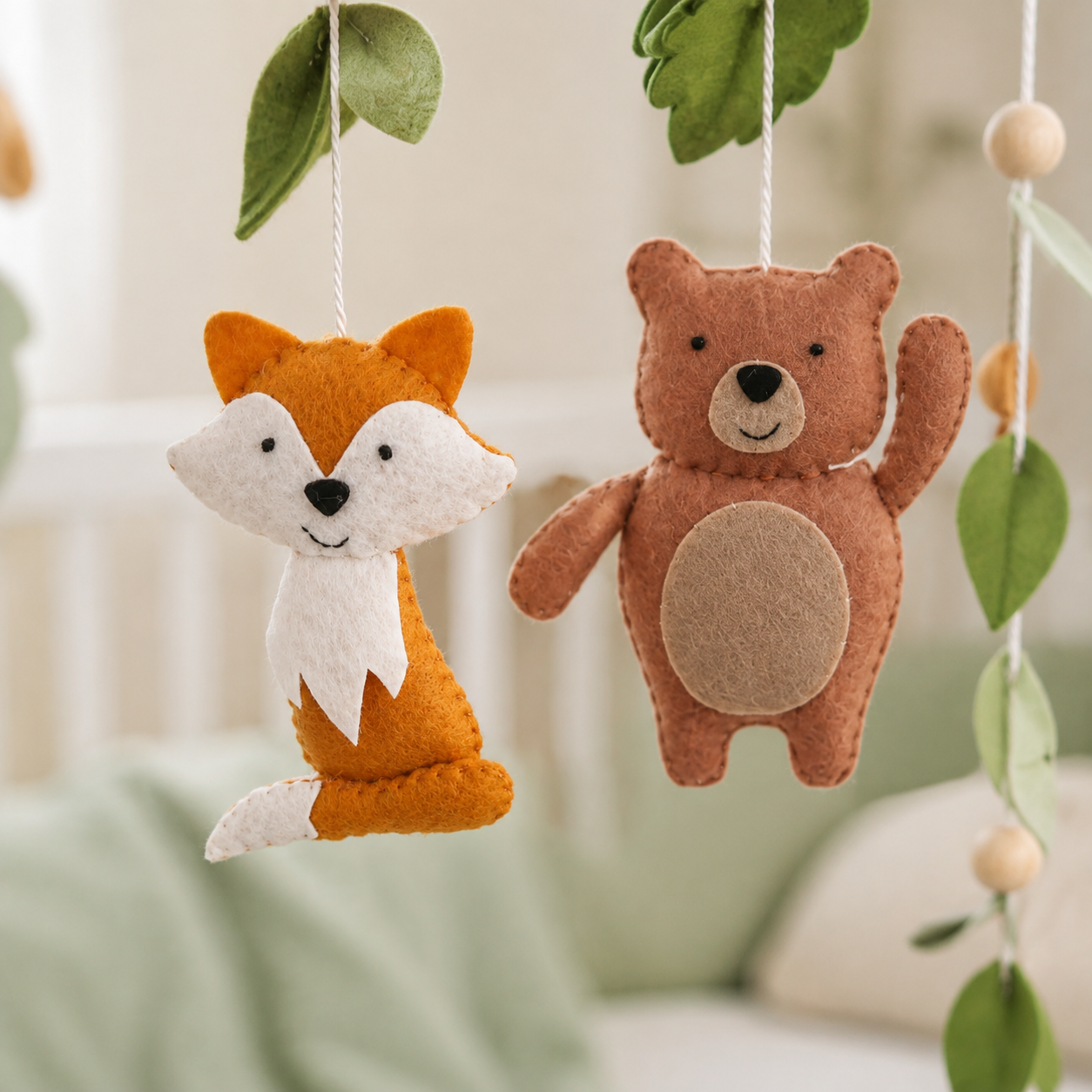Détail du renard et de l’ours en feutrine du mobile bébé