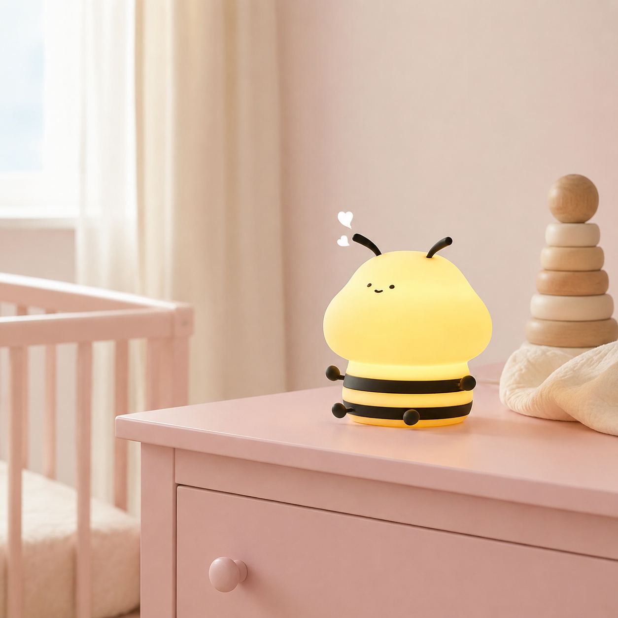 Veilleuse abeille posée sur une commode dans une chambre bébé rose