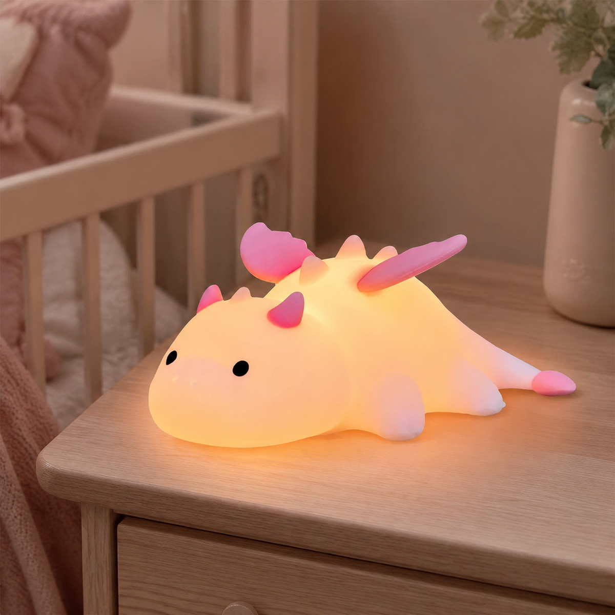 Veilleuse bébé dinosaure rose rechargeable dans une chambre de bébé